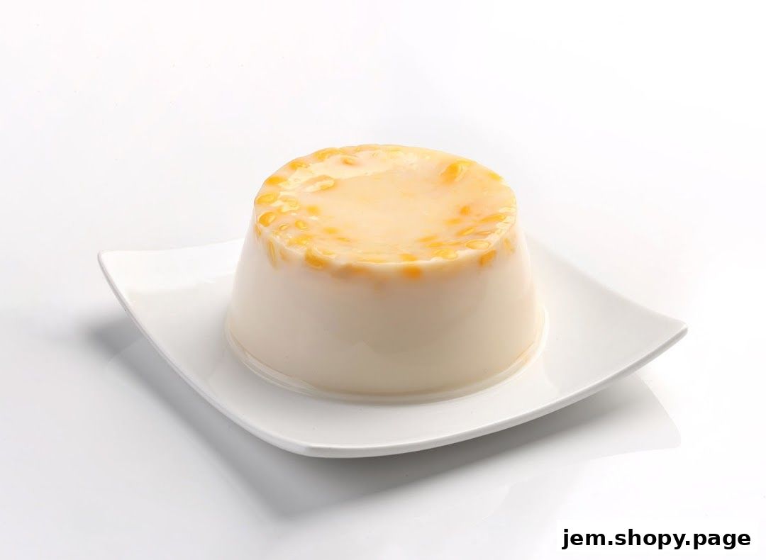 A creamy dessert with corn kernels on top, served on a white plate.