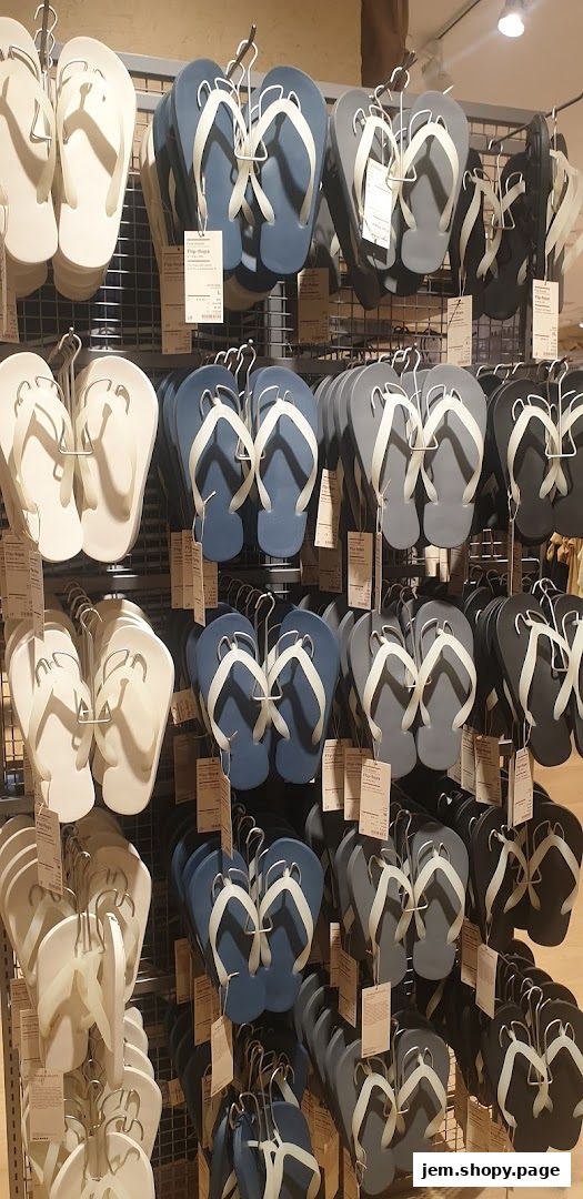 A display of various colored flip-flops hanging on racks in a retail store.