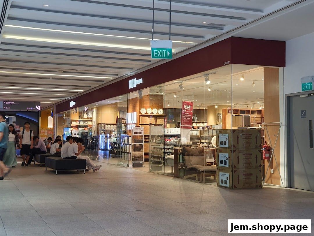 The exterior of a MUJI store with a glass facade displaying various home goods and furniture.