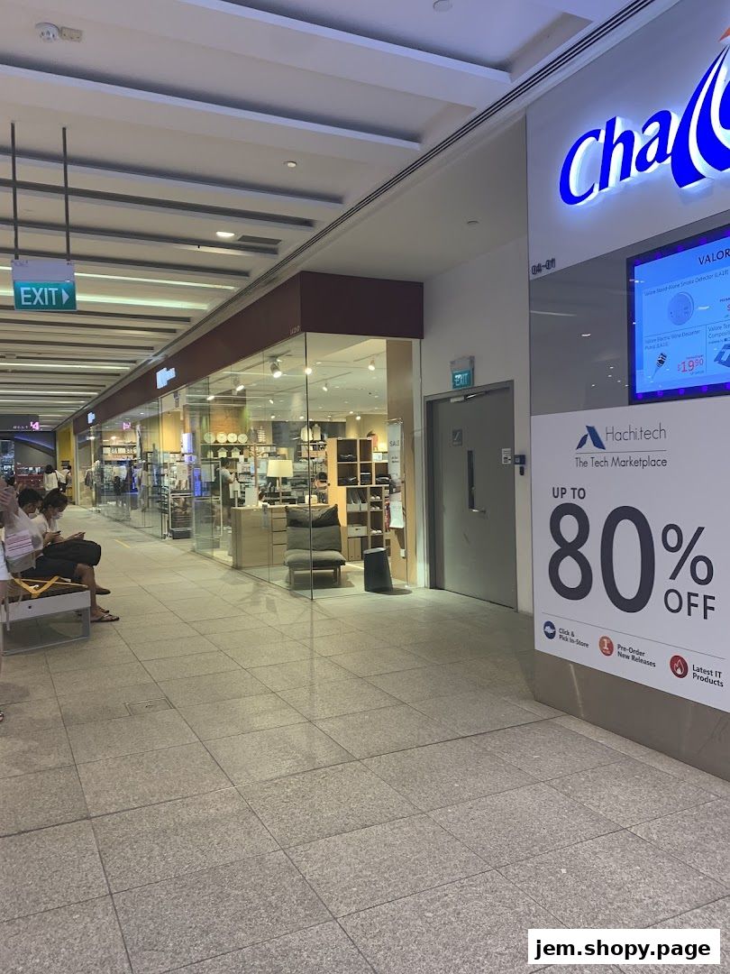 A view of a shopping mall corridor with MUJI JEM and Hachitech stores visible.