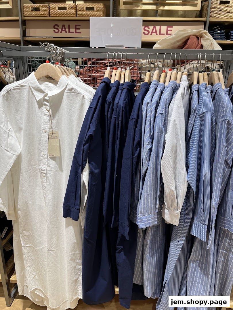 A display of various shirts and dresses on hangers, with a 'SALE' sign in the background.