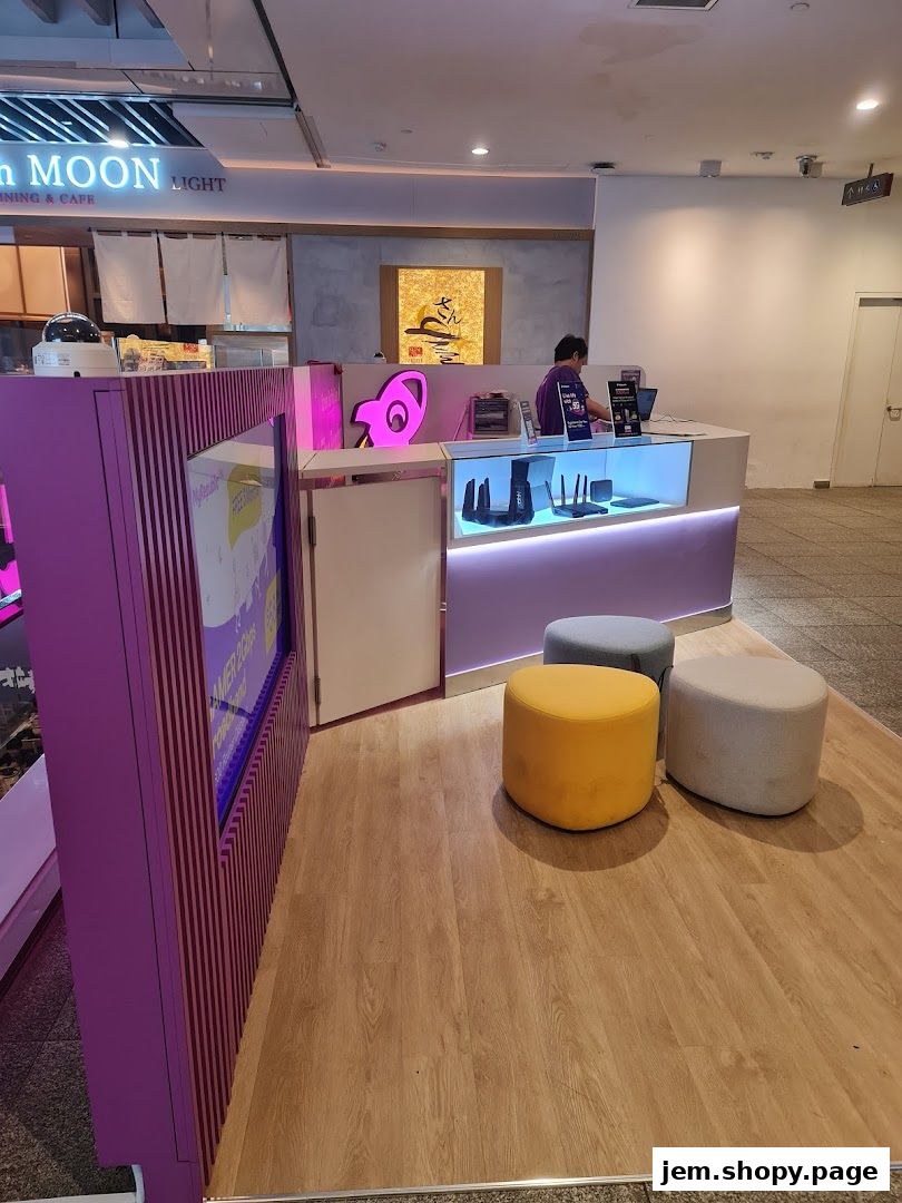 A modern retail store counter with routers displayed and seating area.