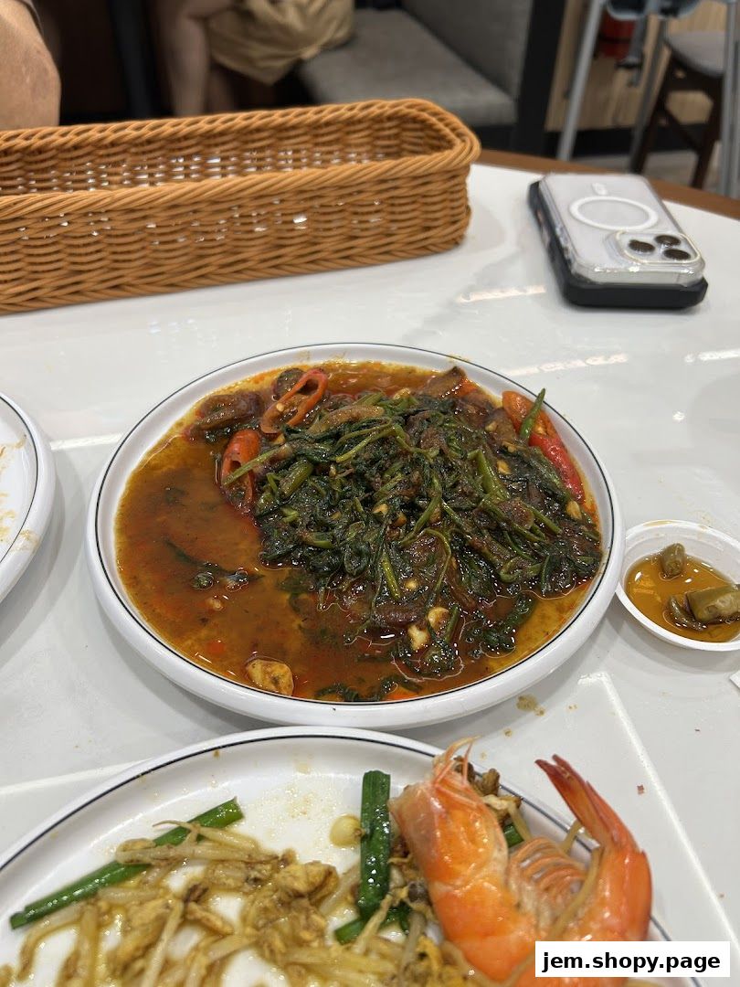 A close-up of delicious Asian dishes, including stir-fried vegetables and shrimp, served on plates.