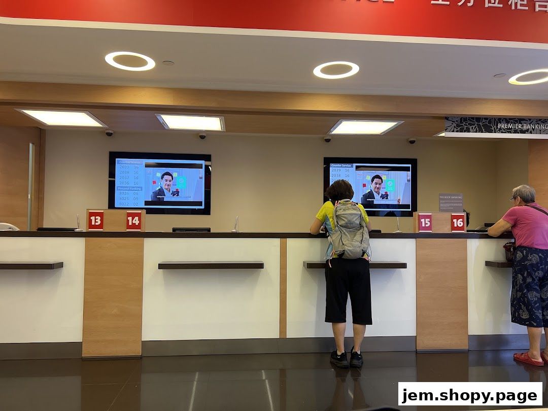 Customers at the counter of OCBC Bank JEM, with digital displays showing queue numbers.