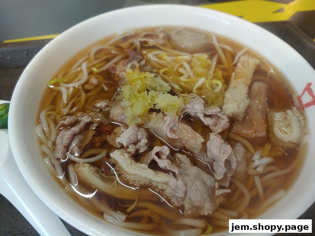 A close-up shot of a steaming bowl of beef noodles with fresh ingredients.