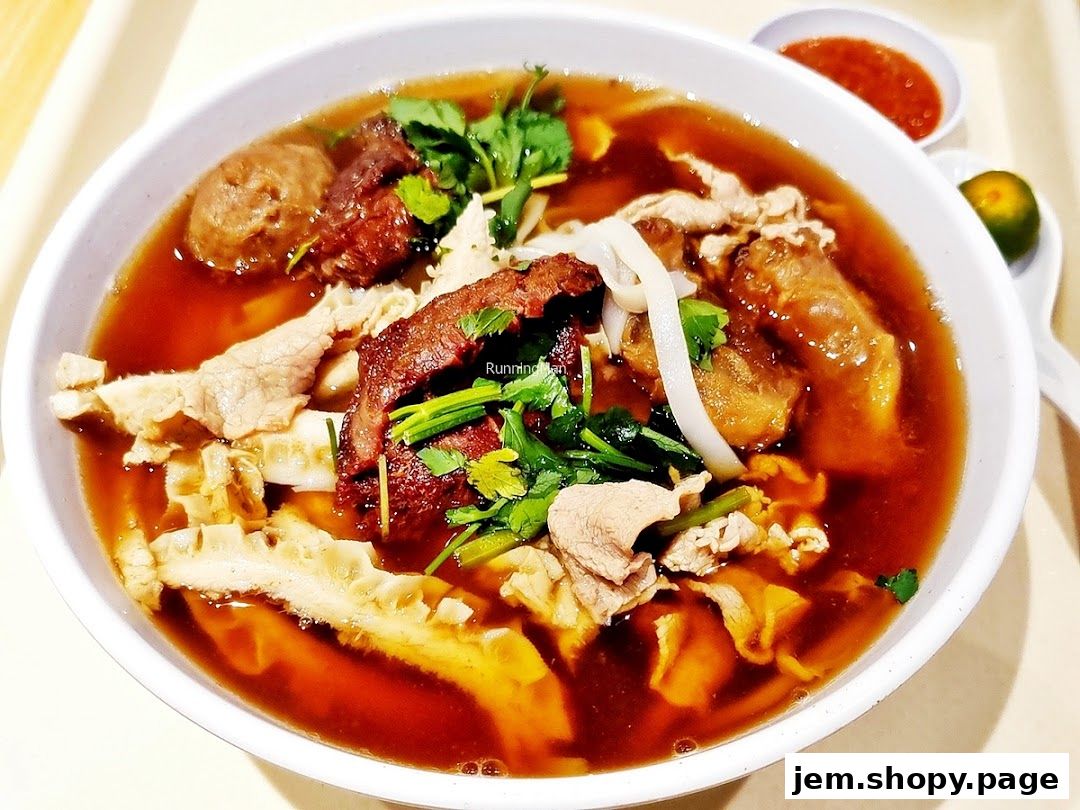 A close-up shot of a hearty bowl of beef noodles with various cuts of beef and tripe.