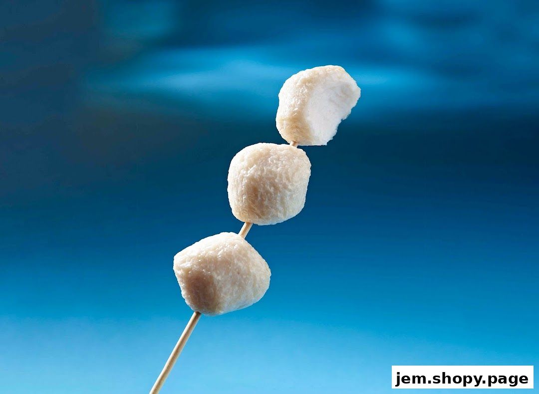 Three white fish balls on a skewer against a blue background.