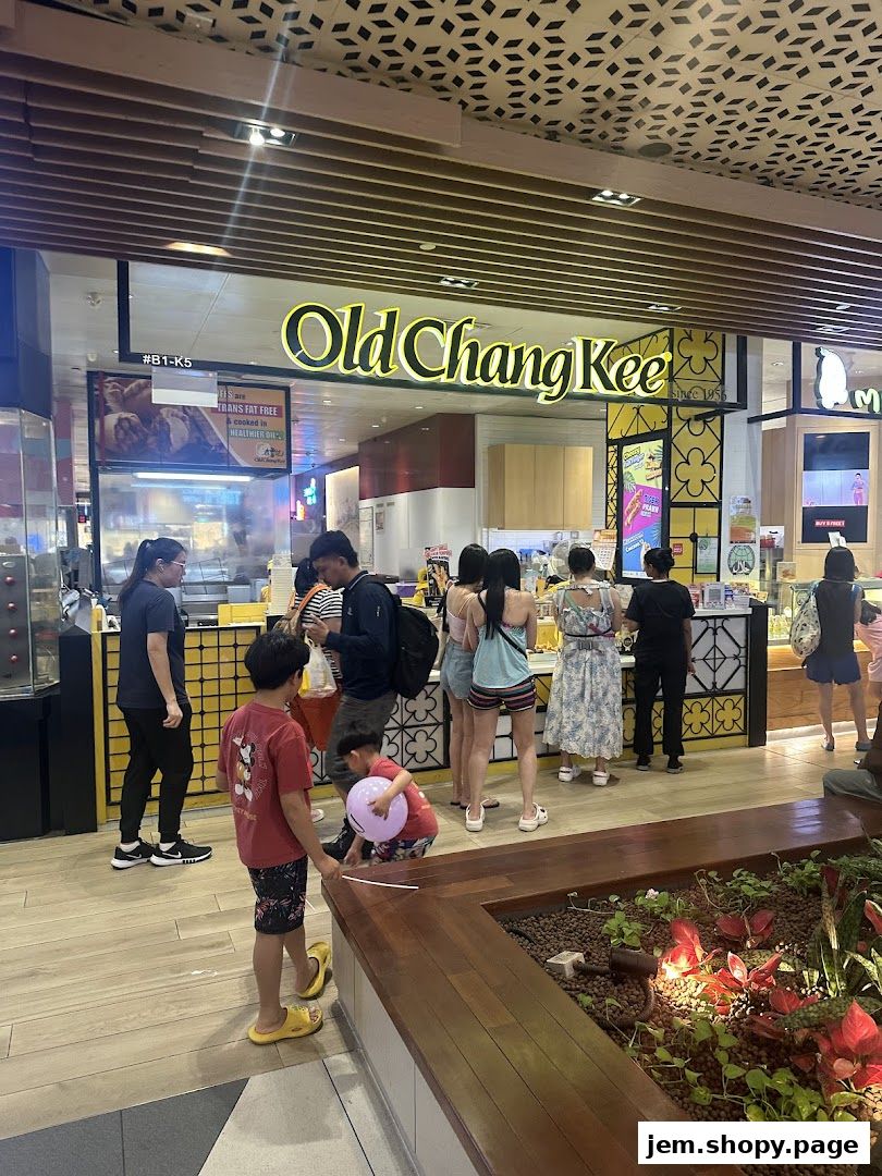 People queuing at the Old Chang Kee shop entrance, with signage visible.