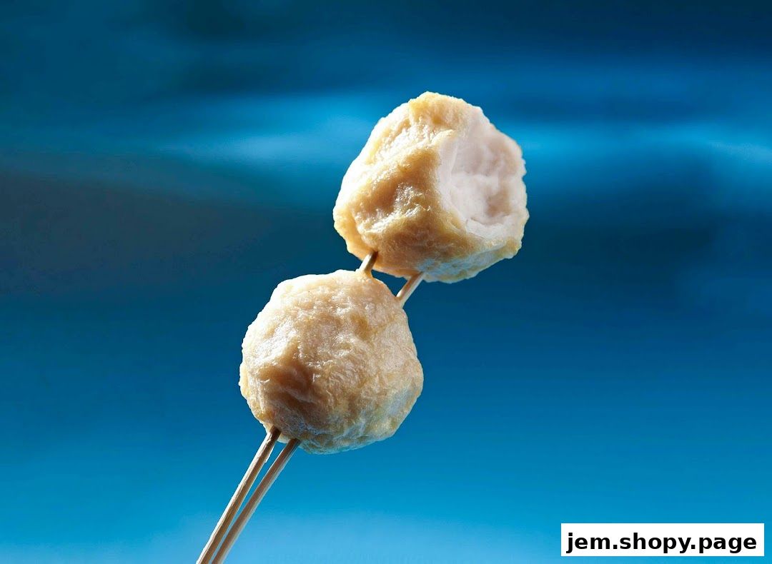 Two golden-brown fish balls on skewers against a vibrant blue background.