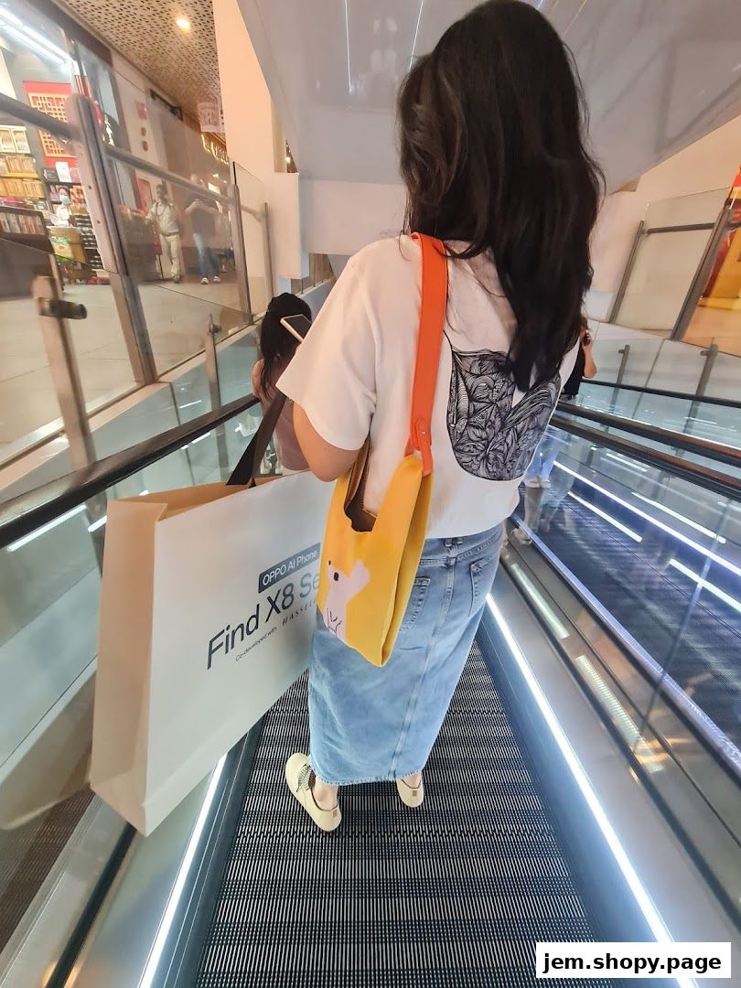 A person on an escalator holding a shopping bag from OPPO.