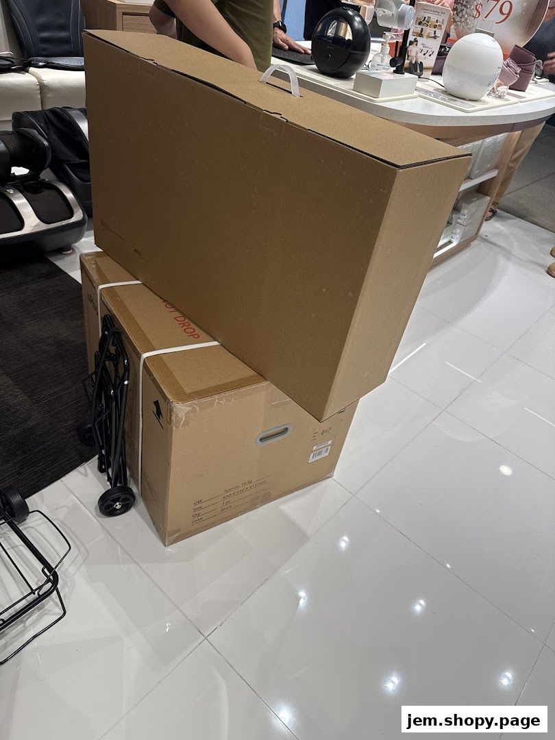 Two large cardboard boxes are stacked in front of a retail store display.