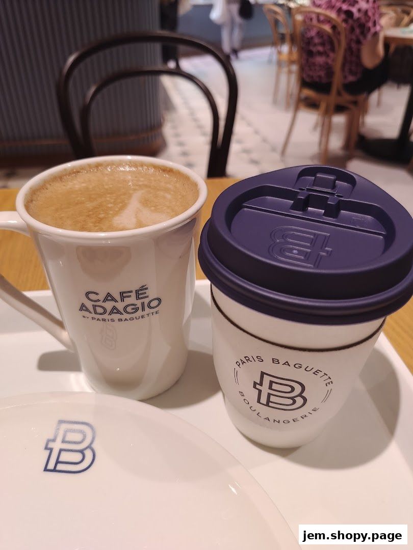 A close-up of two coffee cups and a plate from Paris Baguette.