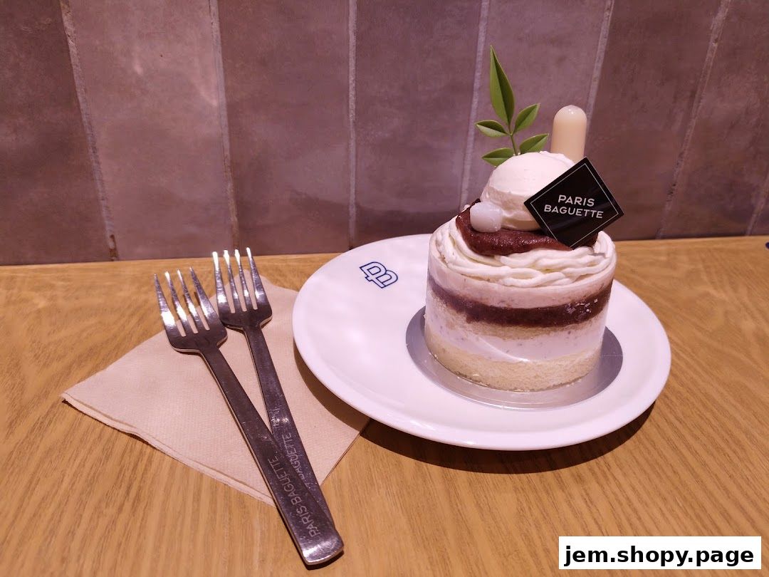 A beautifully decorated cake from Paris Baguette with two forks on a napkin.