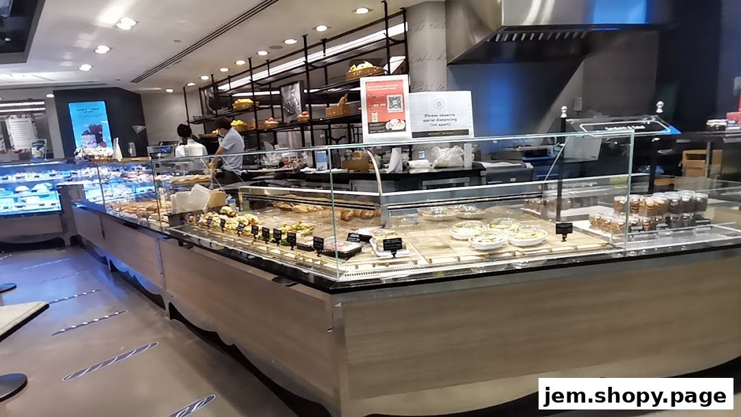 Interior view of Paris Baguette Jem showcasing a variety of pastries, sandwiches, and desserts in display cases.
