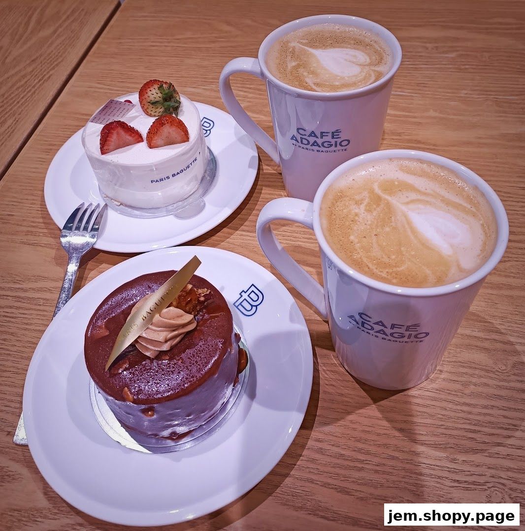 Two delicious cakes and two coffees with latte art on a wooden table.