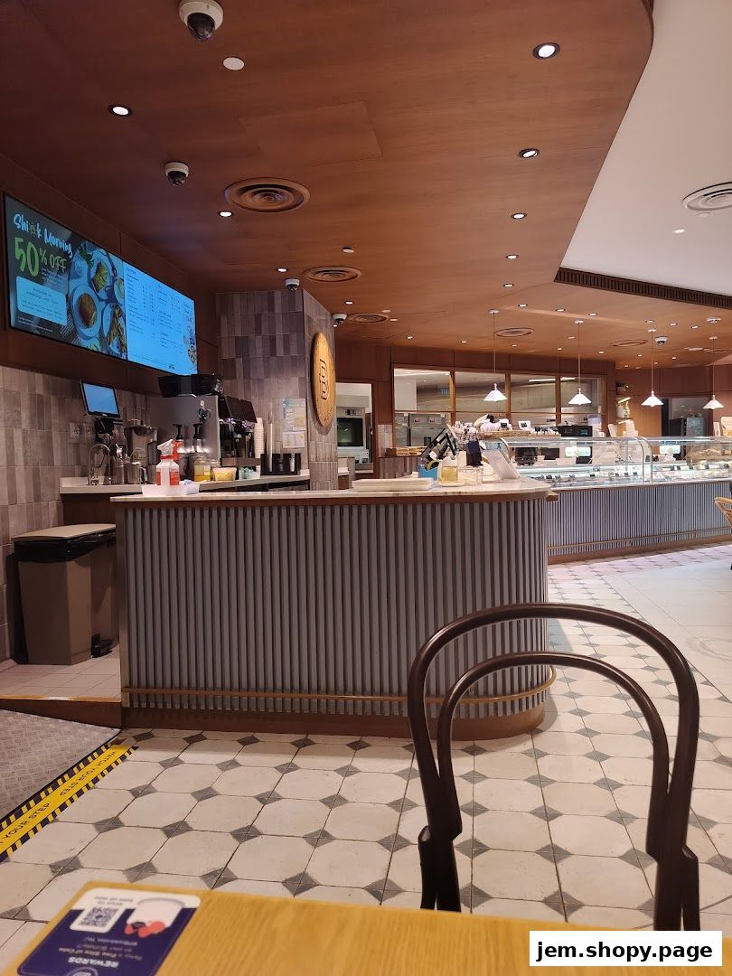 Interior view of Paris Baguette Jem with a counter, display cases, and seating.