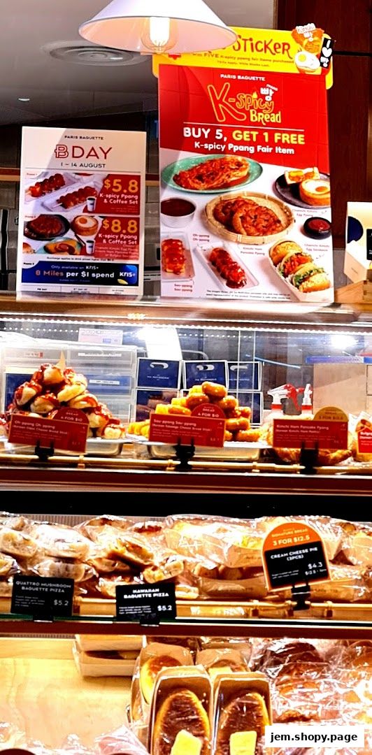 Paris Baguette displays a variety of baked goods and promotional offers in a display case.
