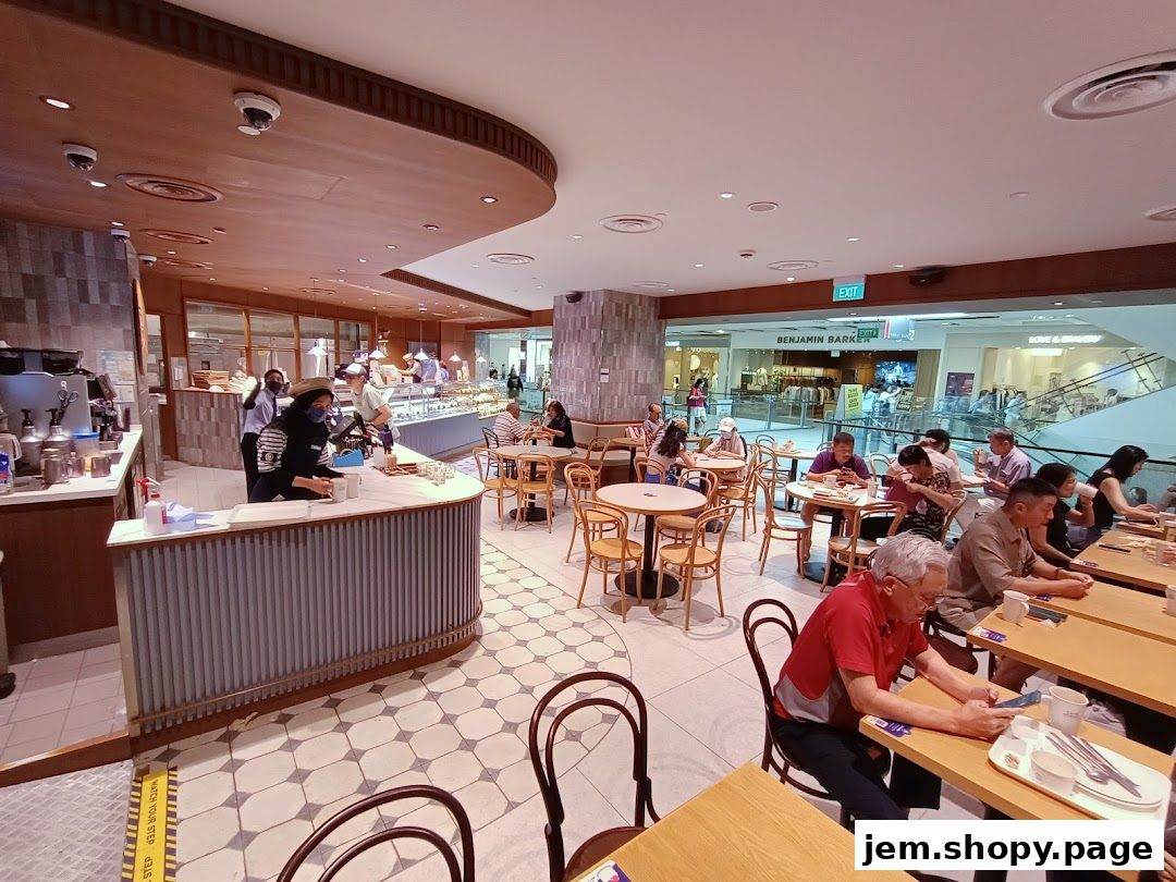 Interior view of Paris Baguette Jem cafe with customers dining and staff serving.