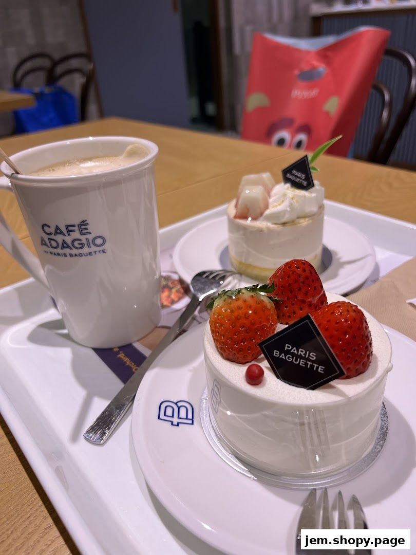 A tray with two mini cakes and a cup of coffee from Paris Baguette.