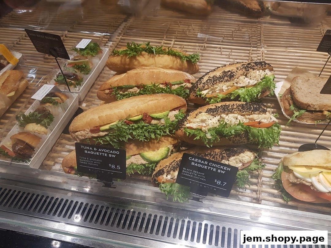 A display case filled with various sandwiches and mini burgers from Paris Baguette.