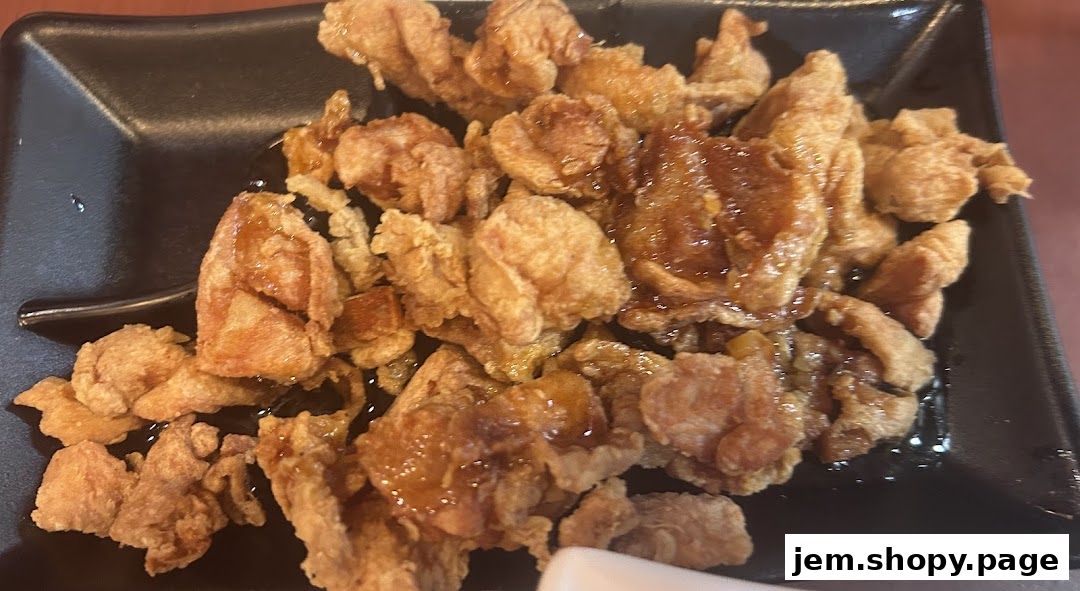 A plate of crispy fried chicken pieces drizzled with a sweet glaze.