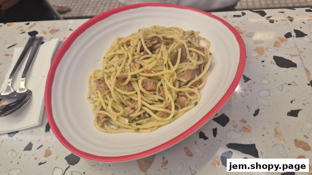 A close-up shot of a delicious spaghetti dish served in a white bowl with a pink rim.