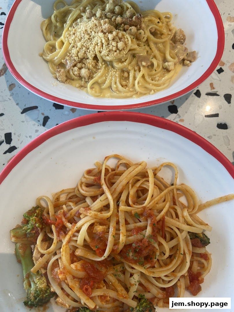 Two bowls of pasta, one with a creamy sauce and crumble, the other with tomato sauce and broccoli.