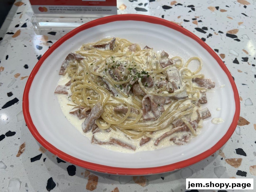A close-up shot of a creamy pasta dish with bacon and herbs.