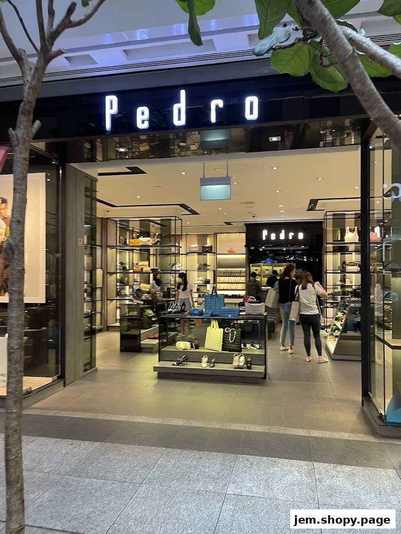 The entrance of a PEDRO Jem shoe and accessory store, showcasing handbags and footwear.