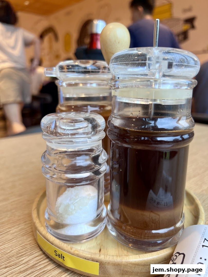 Close-up of salt and sauce dispensers on a table at Pepper Lunch.