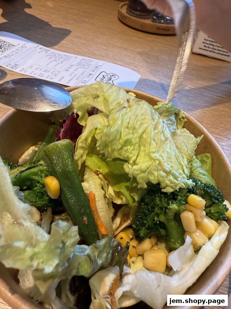 A close-up of a fresh salad with lettuce, broccoli, corn, and green beans.