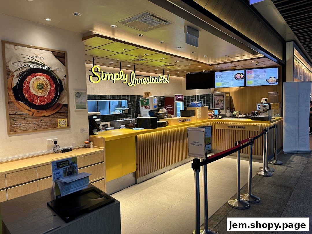 The interior of a Pepper Lunch restaurant with a counter and menu screens.
