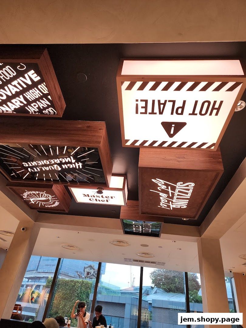Interior view of Pepper Lunch with ceiling decor and diners visible through the window.