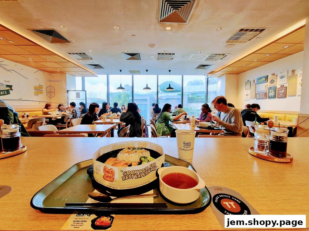 A Pepper Lunch meal served on a tray with a drink and condiments in a restaurant.