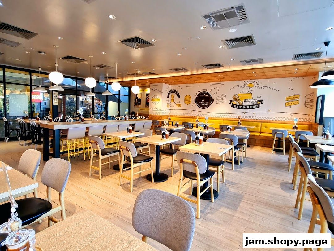 Interior view of Pepper Lunch restaurant with tables, chairs, and a long counter.