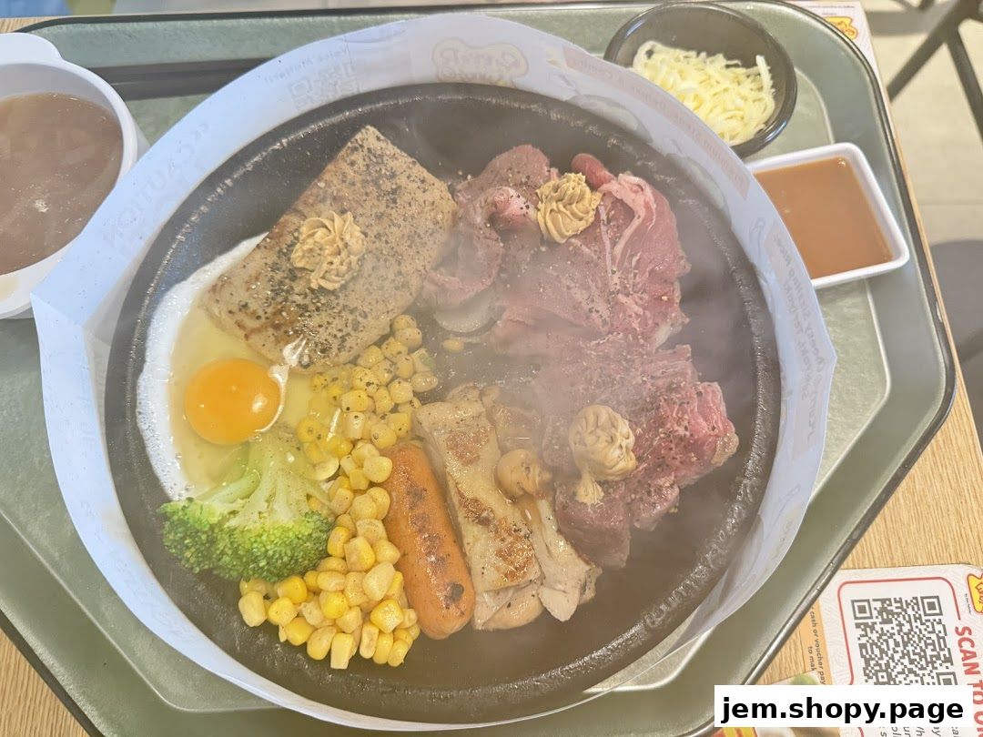A sizzling hot plate meal with steak, chicken, egg, broccoli, corn, and sausage.