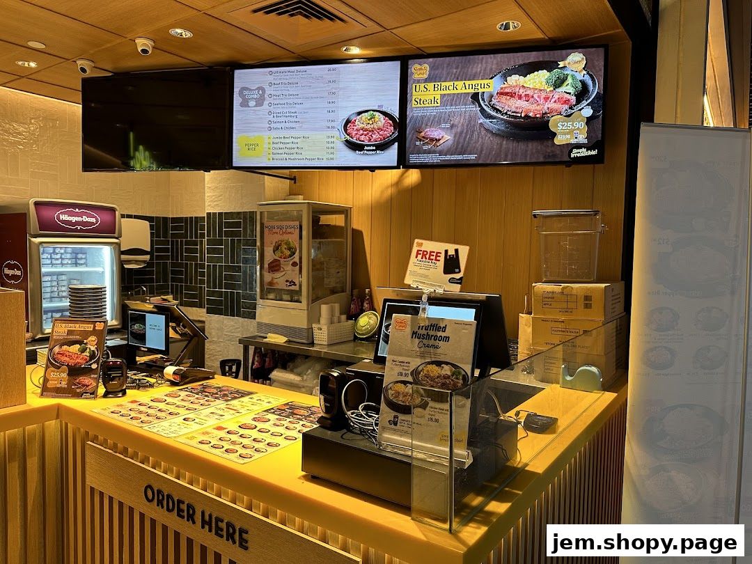 A Pepper Lunch counter displaying menu boards and food items.