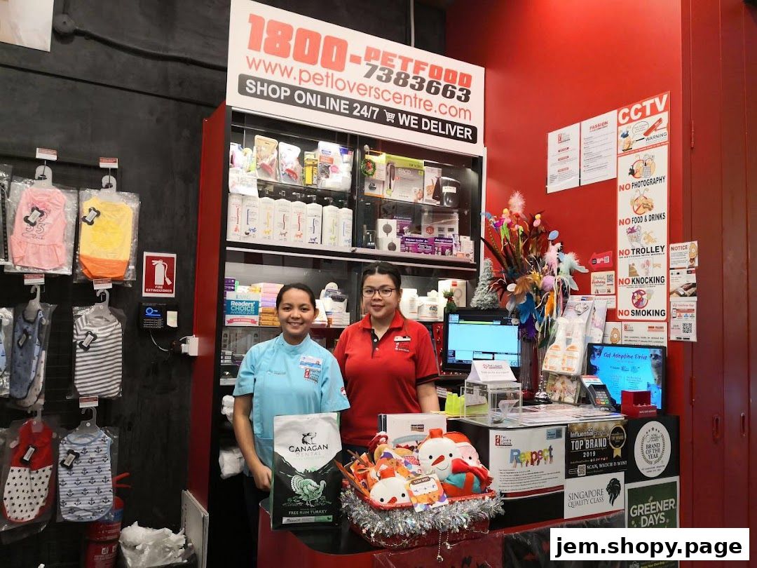 Two staff members stand behind a counter at Pet Lovers Centre, with pet products displayed.