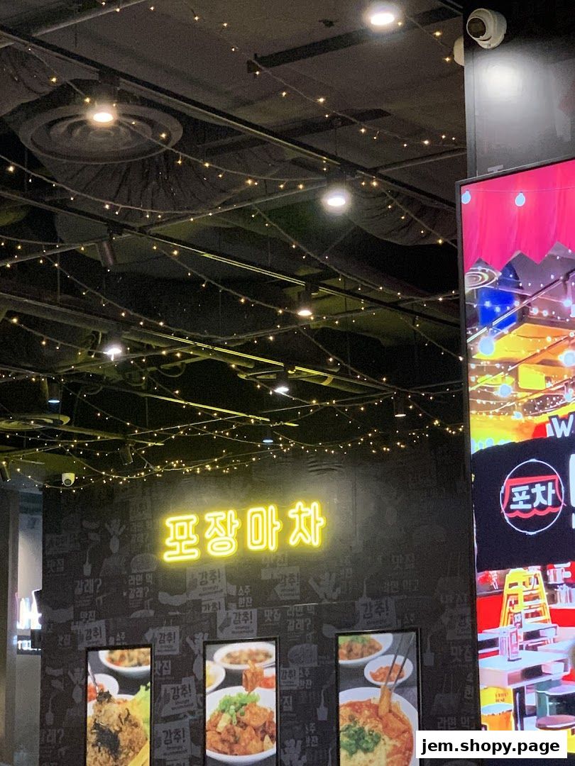 A neon sign reads 'POCHA!' above framed pictures of Korean street food.