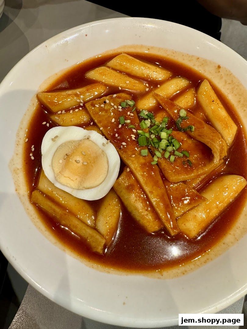 A close-up shot of Tteokbokki, a popular Korean street food dish, in a white bowl.