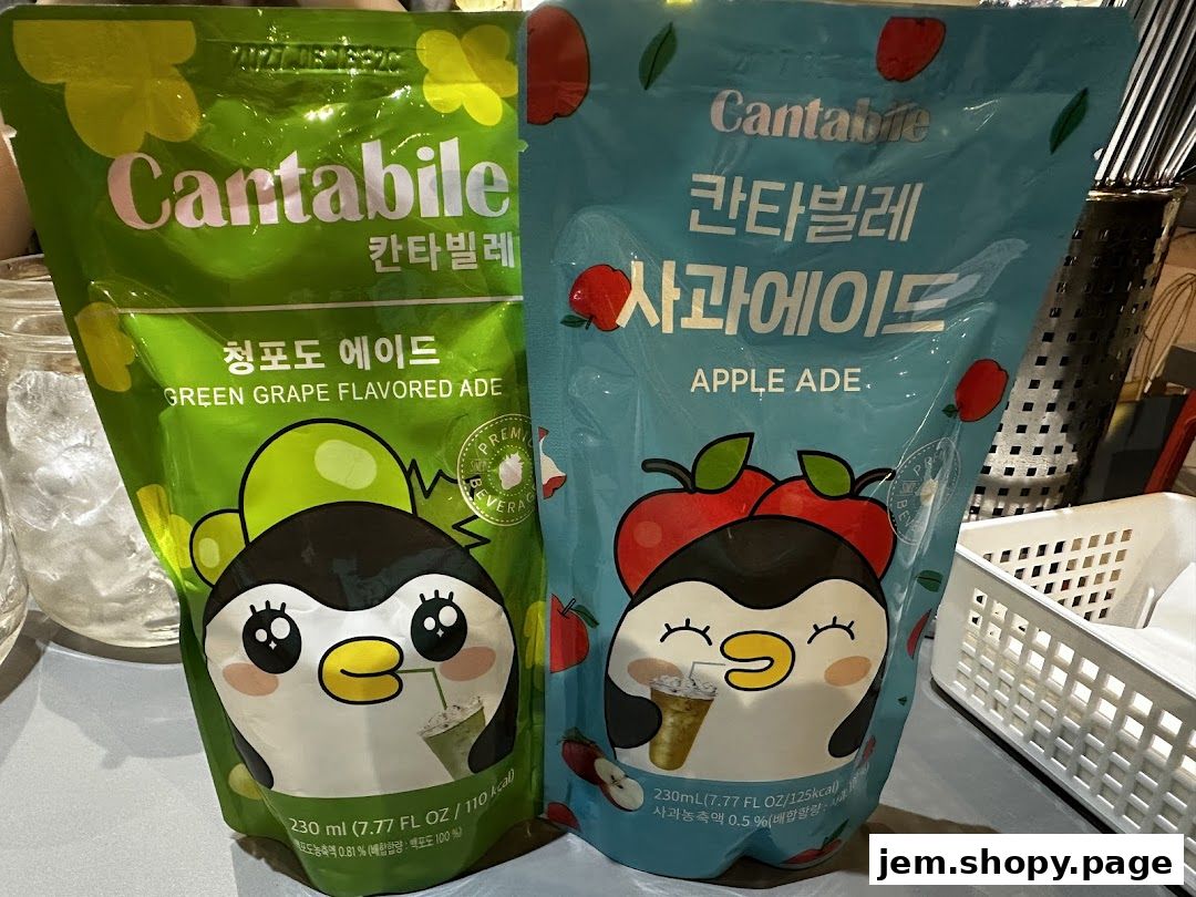 Two pouches of Cantabile flavored ade drinks, one green grape and one apple, featuring cute penguin characters.