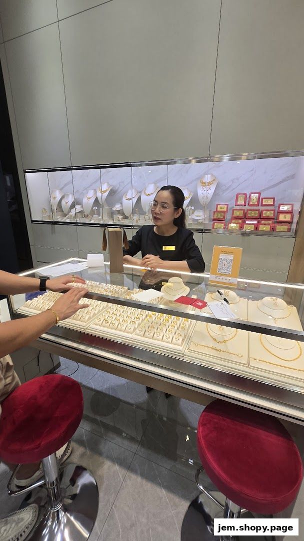 A jewelry store employee assists a customer with rings displayed in a glass case.