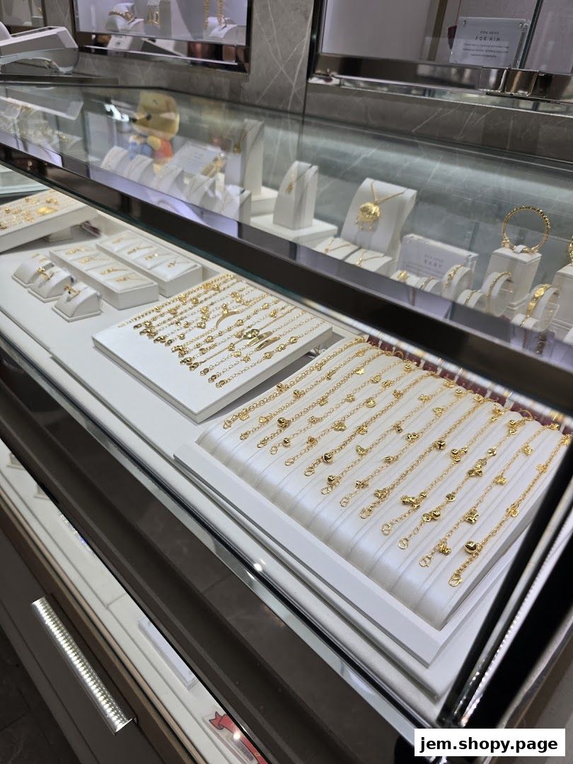 Display of elegant gold bracelets and necklaces in a jewelry store showcase.
