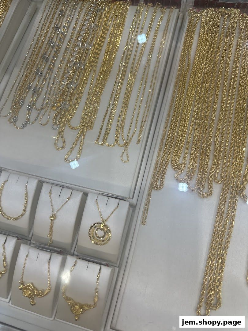 A display of various gold necklaces and pendants in a jewelry store.