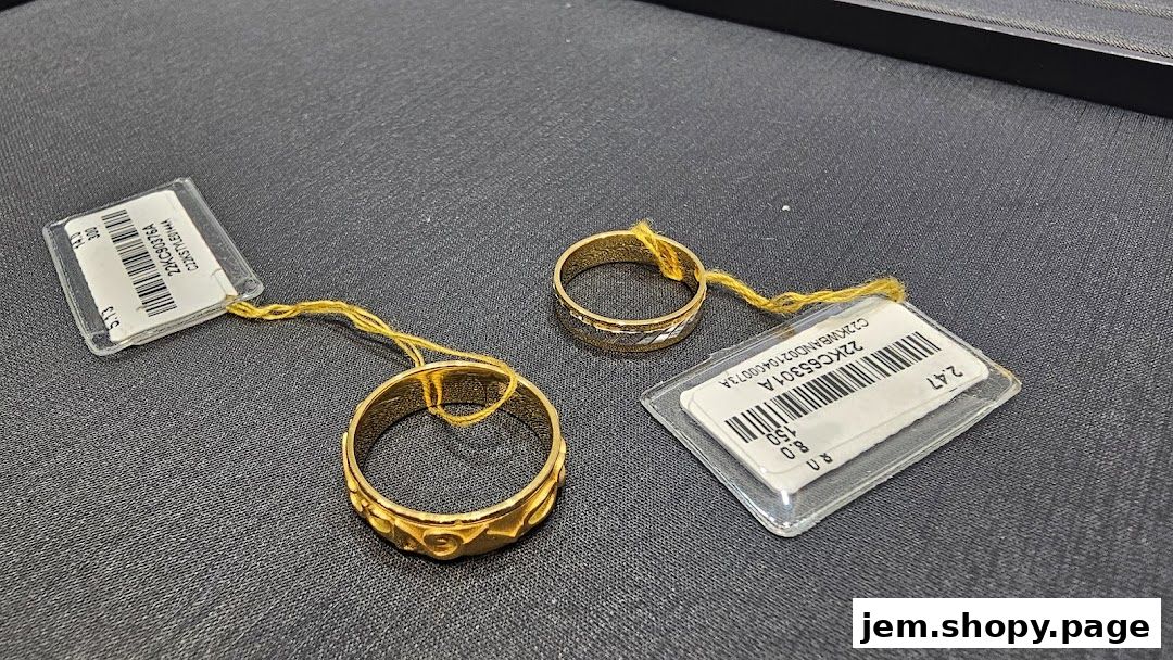 Two gold rings with price tags displayed on a dark surface.