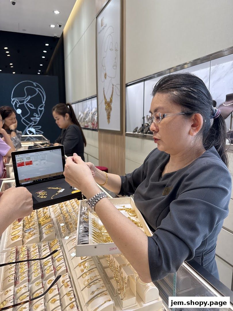 A sales associate assists a customer with jewelry selection at Poh Heng Jewellery.