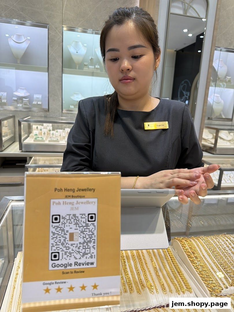 A staff member stands behind a counter displaying jewelry and a Google Review QR code.