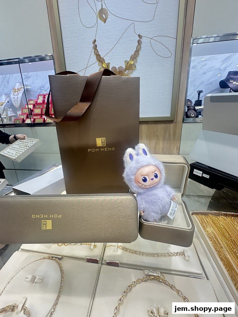 A display of jewelry and branded packaging from Poh Heng Jewellery, with a plush toy.