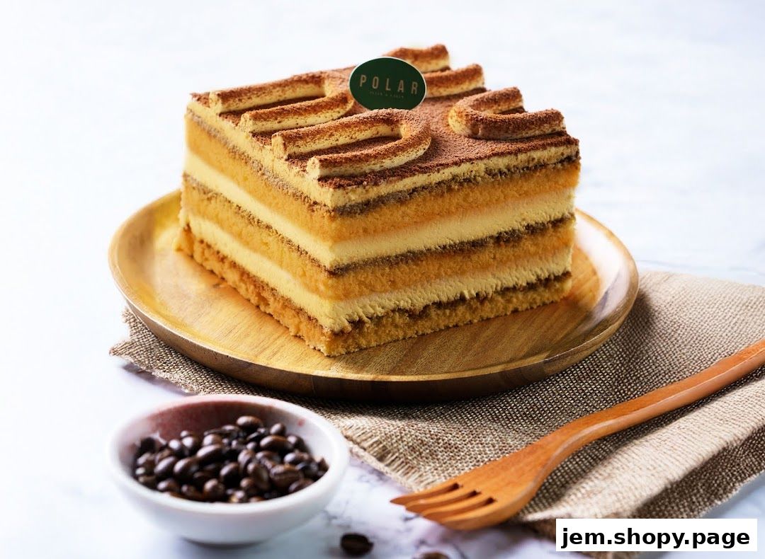 A square tiramisu cake with layers of cream and coffee-soaked sponge, dusted with cocoa.