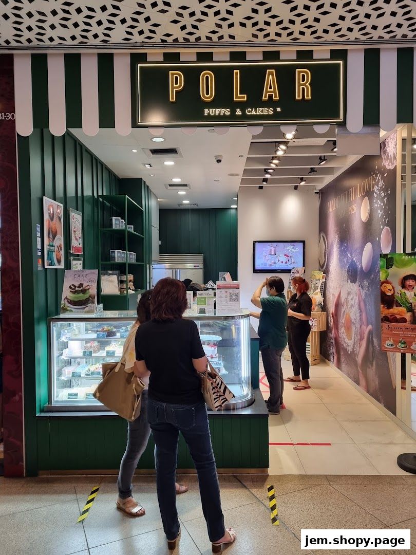 Customers queue at Polar Puffs & Cakes, with a display of cakes visible in the refrigerated counter.